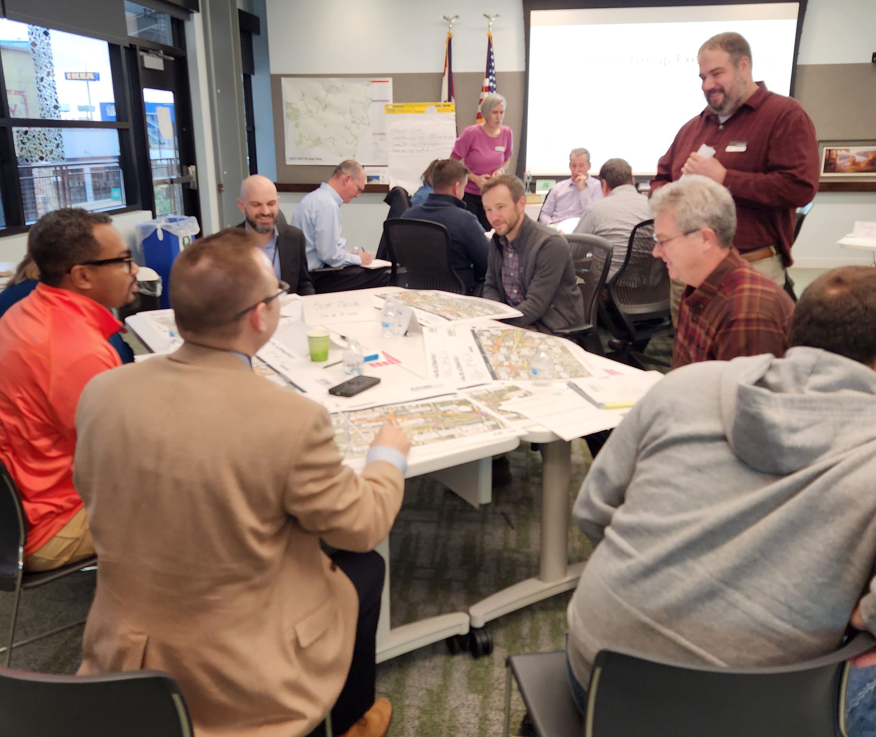 Community members sitting around a table reviewing maps and discussing the study.